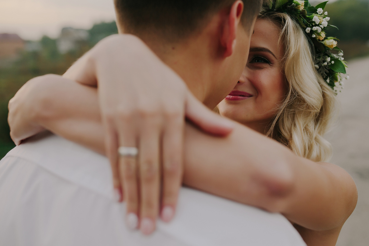 a bride and groom embrace in the sunset 